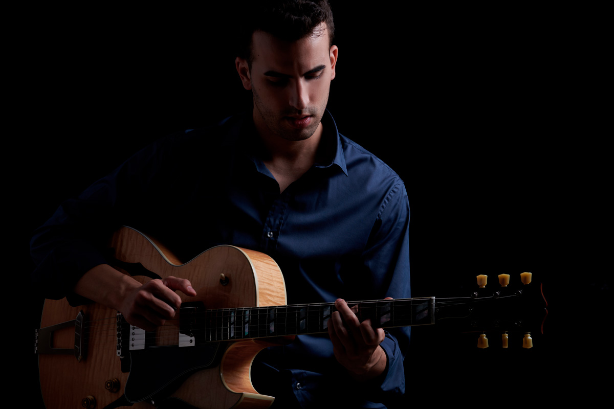 Alein Steinbert tocando guitarra